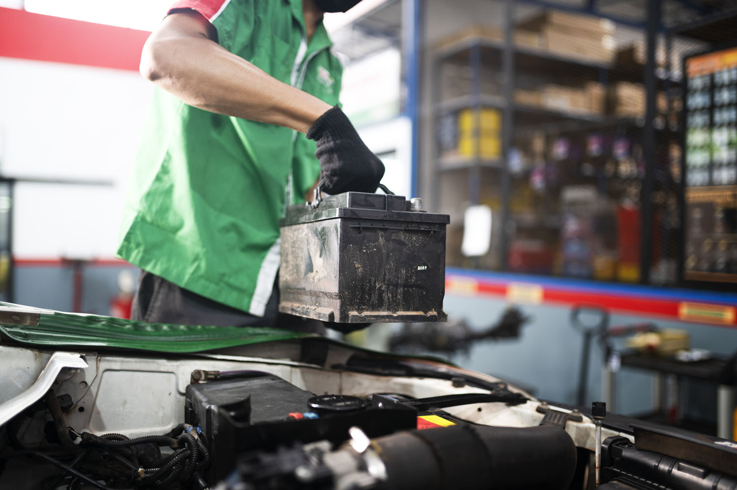 mechanic in green uniform replacing hybrid battery