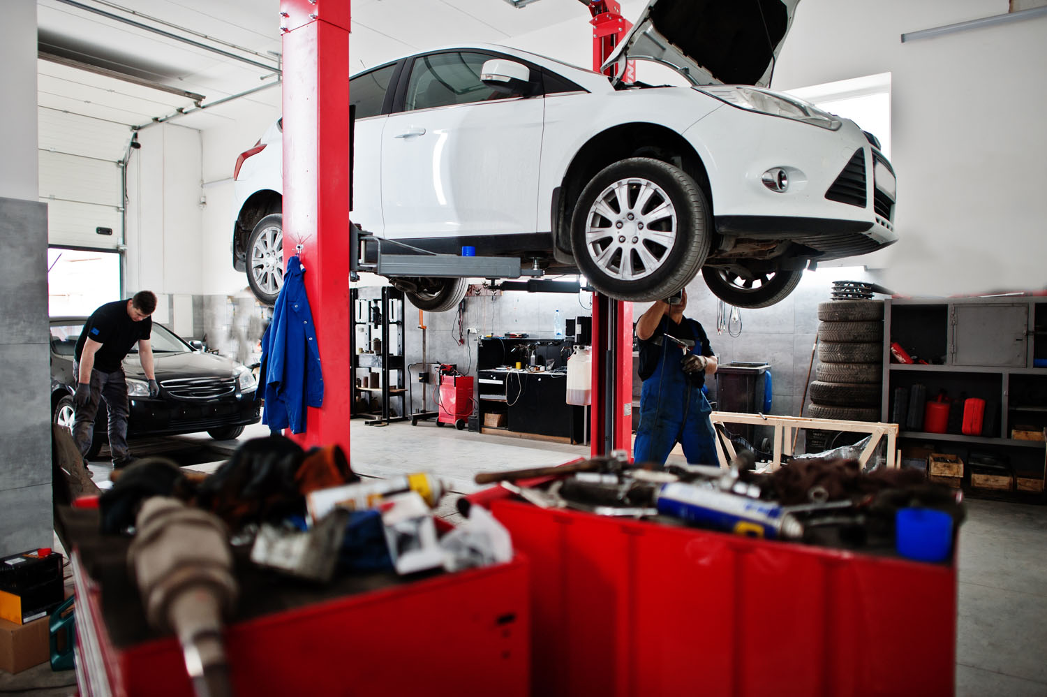 interior of car repair workshop lifting up white car
