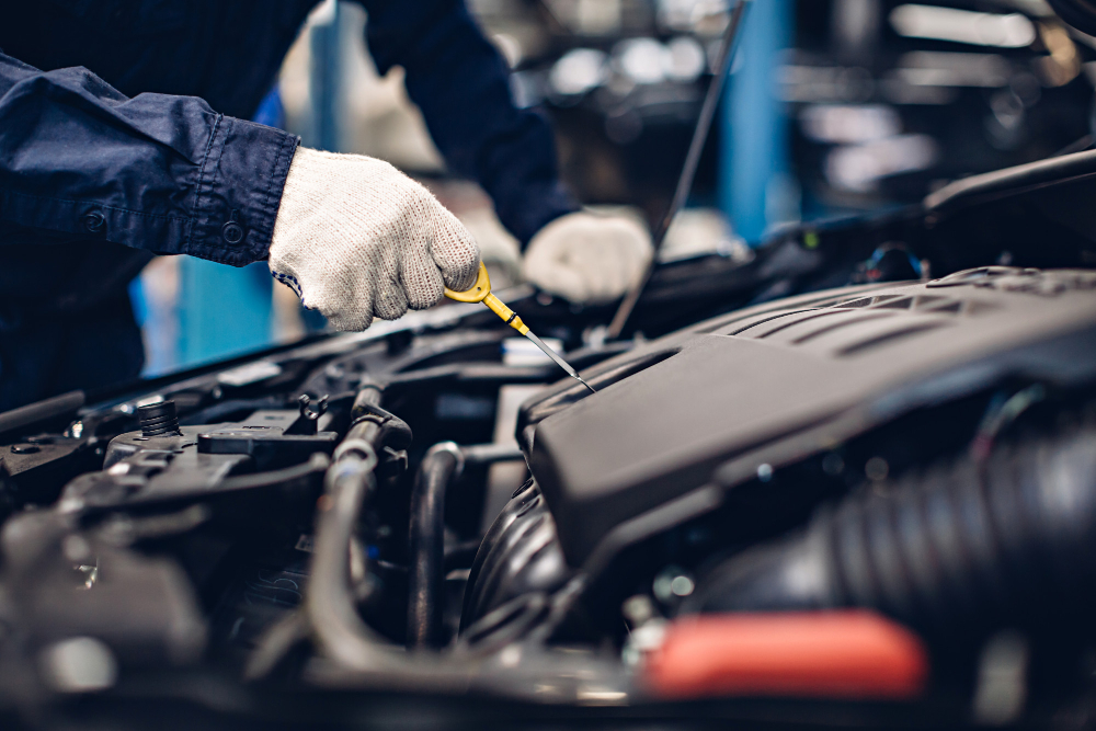 A Jackson PowerTrain Specialist performing an oil change service on a hybrid car engine.