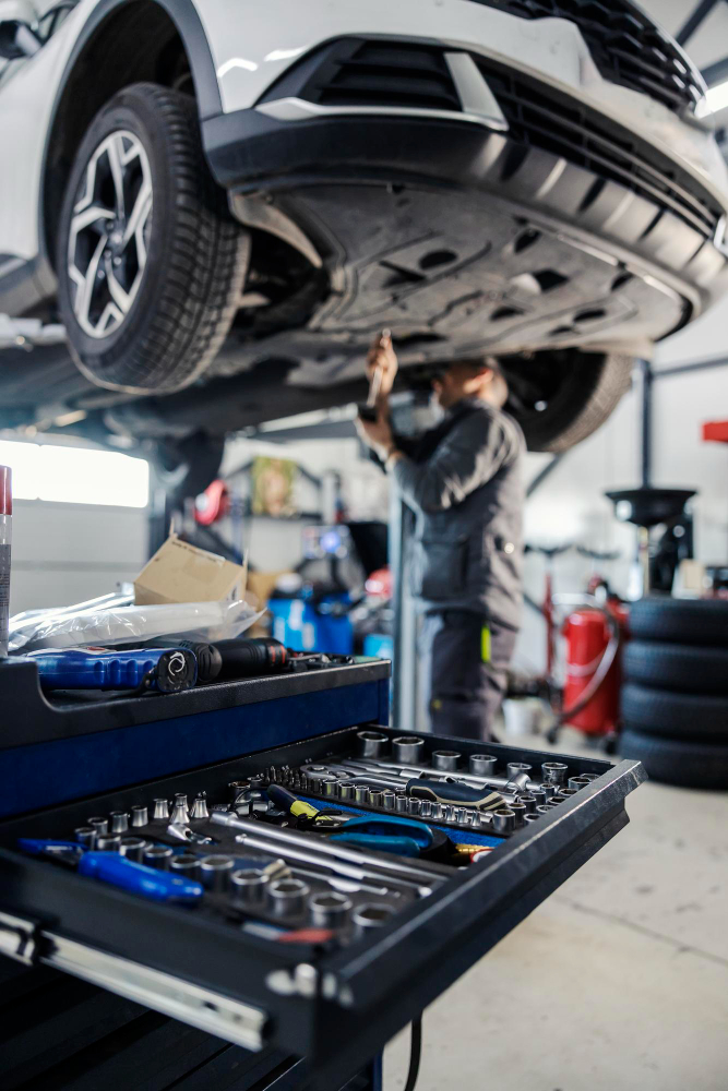 A mechanic is servicing a hybrid car at a Singapore Car Workshop.
