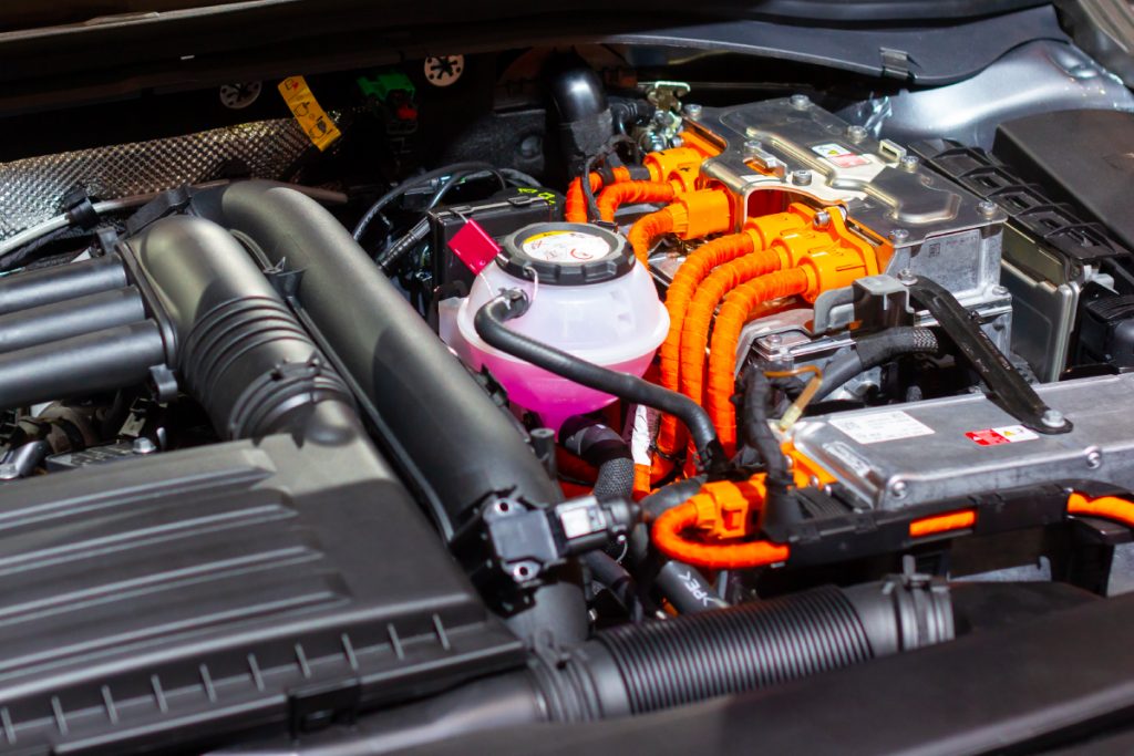 Hybrid car specialist servicing the engine compartment including hybrid battery replacement