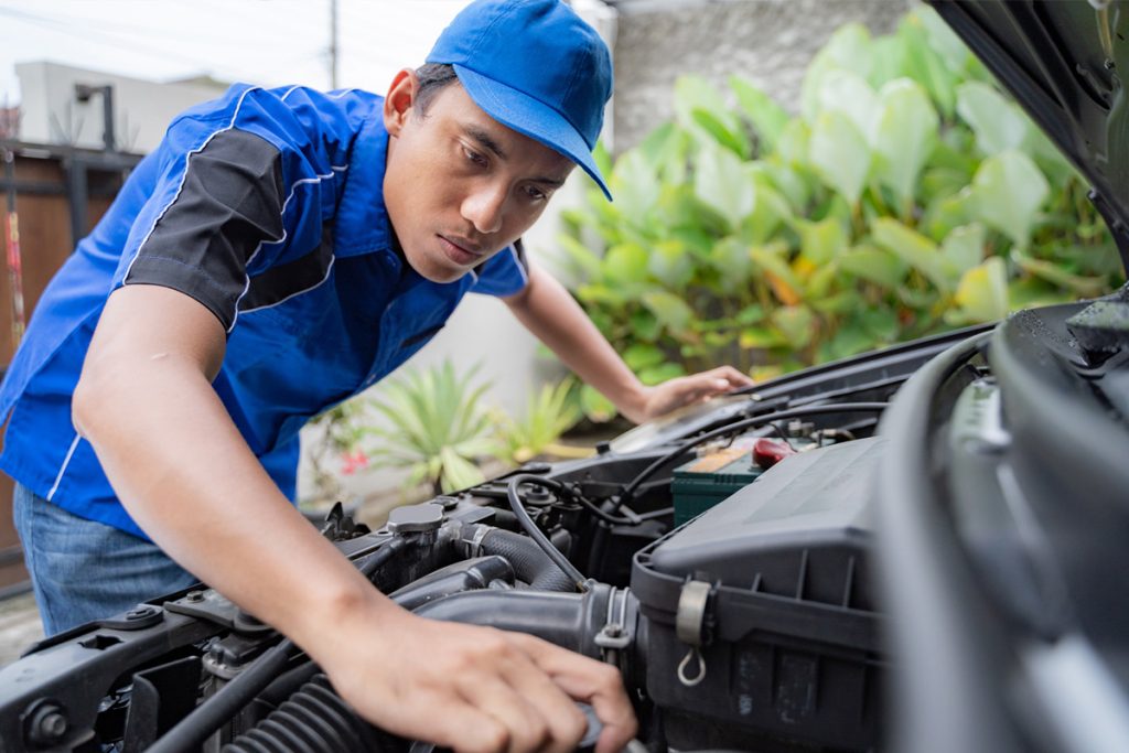 A Jackson PowerTrain mechanic providing a servicing package for the engine of a car.